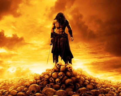 Обои на рабочий стол Главный герой из фильма Конан-варвар / Conan the barbarian стоит на черепах с мечом в руке