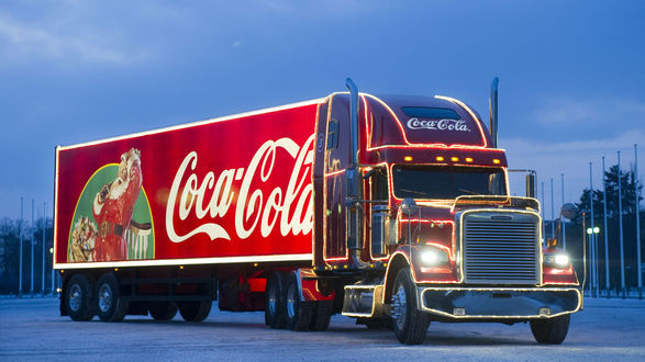 Обои на рабочий стол Праздничная машина CocaCola едет по вечерней дороге