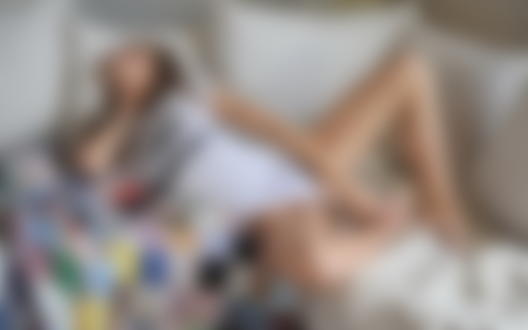 Обои для рабочего стола Девушка уснула на белом диване в странной позе, с цветным лоскутным покрывалом и в белой майке с надписью (This is not a photo apportunity)