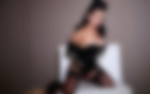 Обои для рабочего стола Сaroline Аquino в чёрном костюме на белом стуле