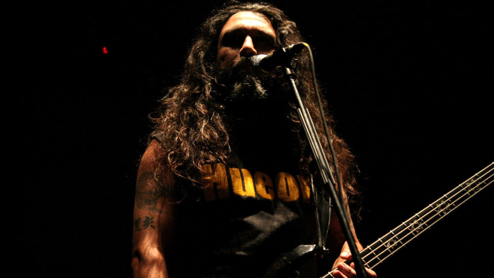 Обои для рабочего стола Том Айра из группы Slayer стоит возле микрофона и держит в руках бас - гитару