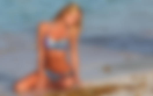 Обои для рабочего стола Модель Кэндис Свэйнпол / Candice Swanepoel сидит на берегу моря