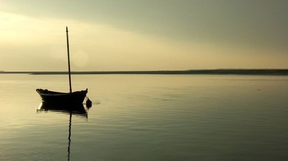 Обои на рабочий стол Одиноко стоящая в тихой воде лодка