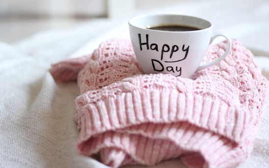 Обои на рабочий стол Чашка кофе с надписью  *Happy Day / Хорошего дня* стоит на розовом свитере