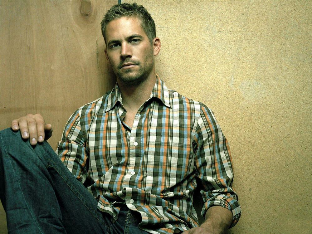 Обои для рабочего стола Пол Уокер / Paul Walker в клетчатой рубашке сидит, прислонившись к стене