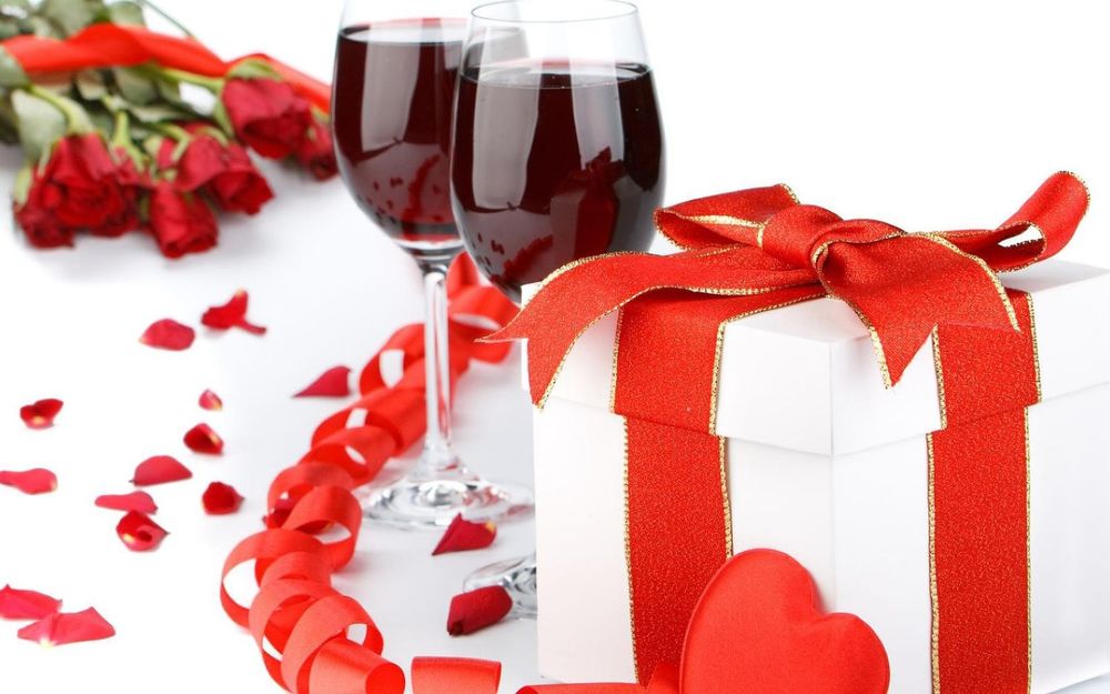 Обои для рабочего стола Два бокала красного вина, подарок с красной ленто и букет красных роз