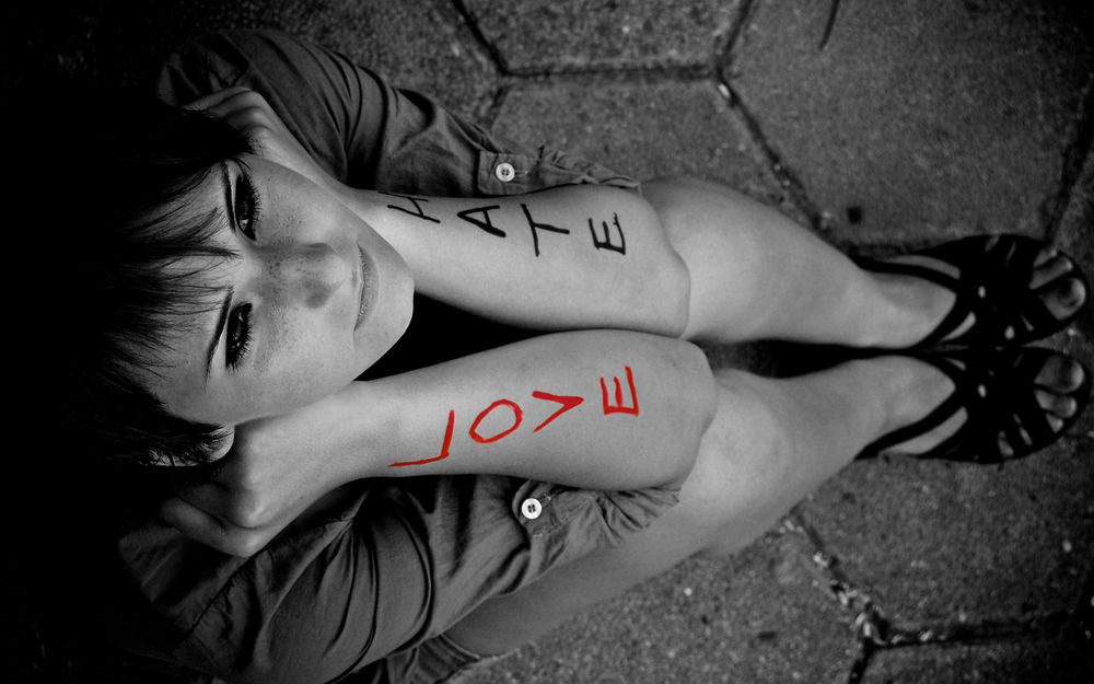 Обои для рабочего стола Гарусная девушка сидит с надписями на руках HATE LOVE