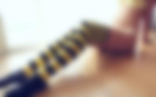 Обои для рабочего стола Девушка в желтом белье и полосатых гетрах сидит на полу