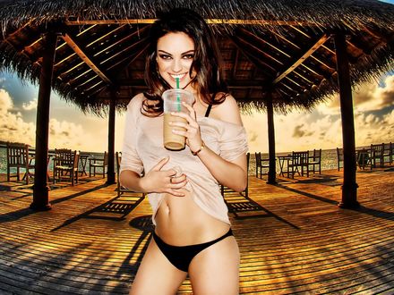 Обои на рабочий стол Mila Kunis / Мила Кунис  с коктейлем стоит на фоне беседки на пляже