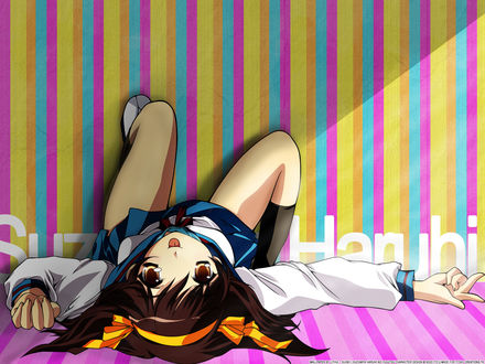 Обои на рабочий стол Suzumiya Haruhi / Харухи Судзумия - главная героиня аниме Меланхолия Харухи Судзумии / The Melancholy of Haruhi Suzumiya лежит на полосатом розовом полу опираясь ногами о яркую в разноцветную полоску стену и показывает язык