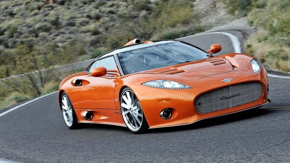 Обои на рабочий стол Spyker C8 Aileron оранжевого цвета стоит на дороге