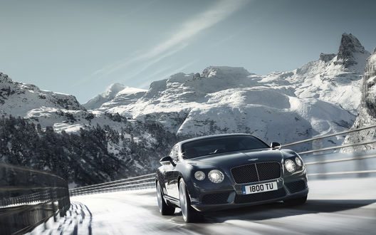 Обои на рабочий стол Черный Bentley / Бентли Continental GT V8 с номерами 1800 TU мчится по дороге, которая лежит в горной местности