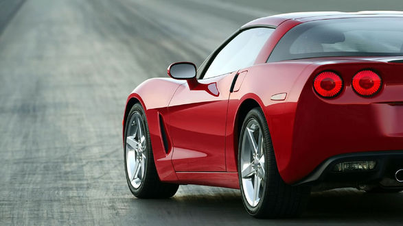 Обои на рабочий стол Ярко красный Chevrolet Corvette C6 2010 г. на дороге