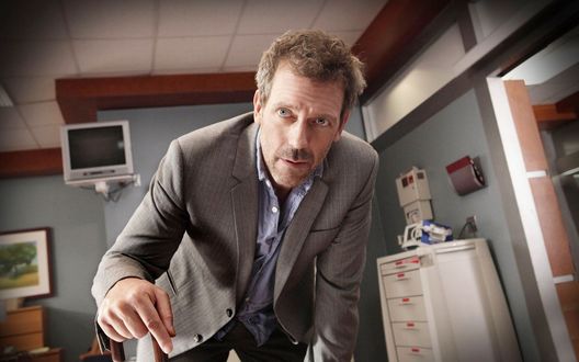Обои на рабочий стол Хью Лори / Hugh Laurie в роли Доктора Хауса в своем кабинете, сериал Доктор Хаус / House M. D