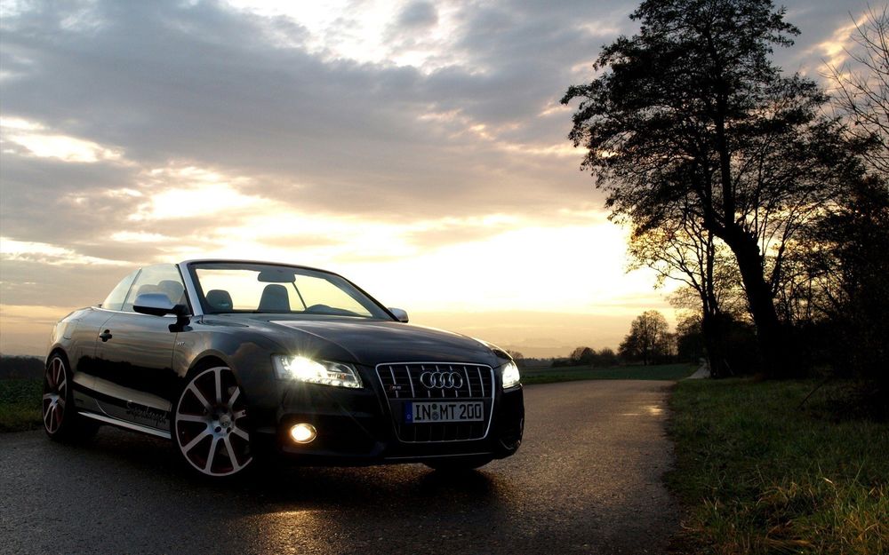 Обои для рабочего стола Audi RS5 стоит на дороге с включенными фарами