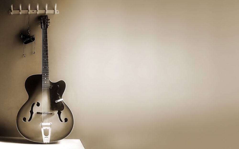 Обои для рабочего стола Полуакустическая электрогитара Гибсон / Gibson стоит у стены