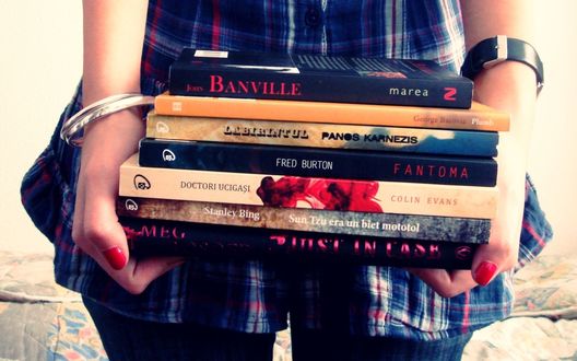 Обои на рабочий стол Девушка стоит со стопкой книг в руках