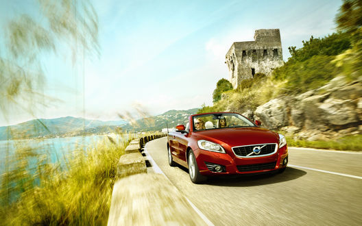 Обои на рабочий стол Красный автомобиль Volvo c70 / Вольво с70 едет по дороге