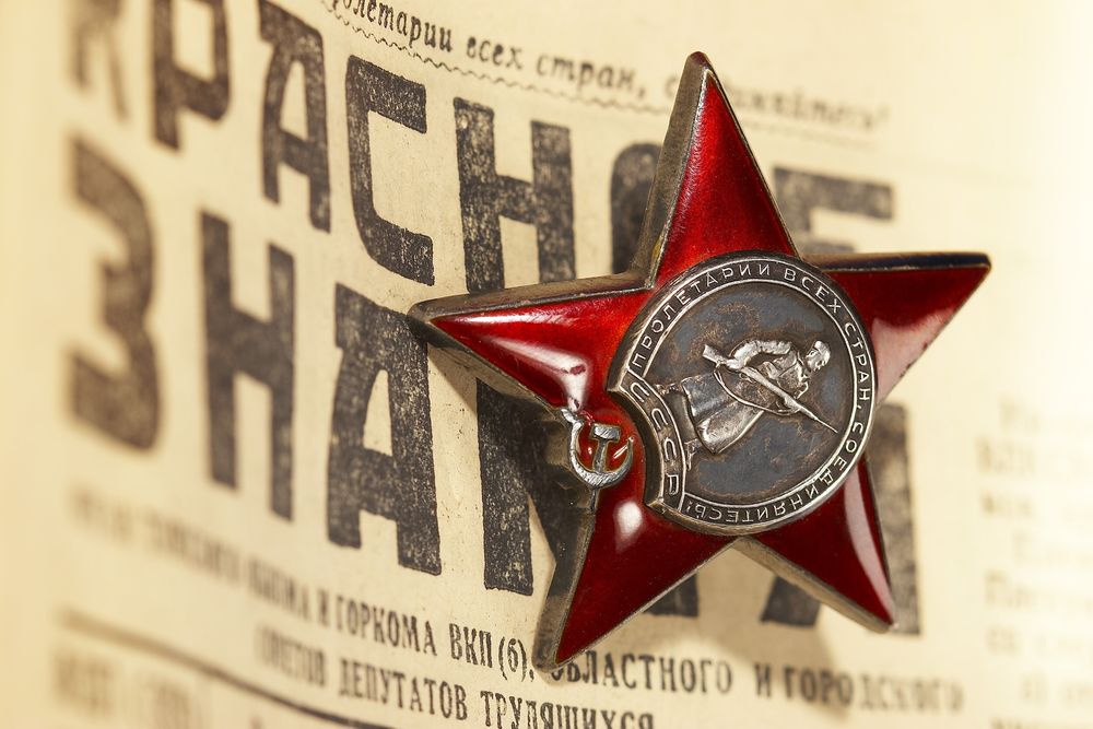 Обои для рабочего стола Орден красной звезды учрежден Постановлением Президиума ЦИК СССР от 6 апреля 1930 года с надписью 'Пролетарии всех стран,соединяйтесь!' лежит на газете 'Красное знамя'