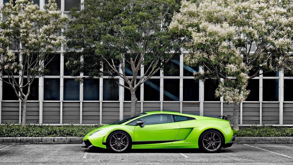 Обои для рабочего стола Green Lamborghini / Зеленое Ламборгини стоит на дороге у дома