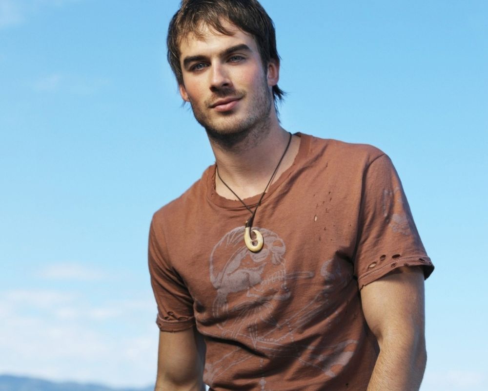 Обои для рабочего стола Иэн Джозеф Сомерхолдер / Ian Joseph Somerhalder в коричневой футболке с кулоном на фон неба