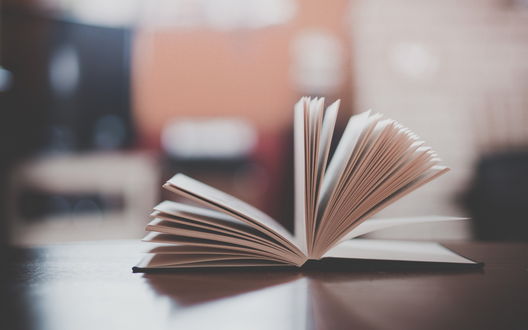 Обои на рабочий стол Раскрытая книга лежит на столе