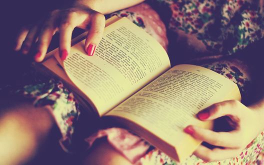 Обои на рабочий стол Раскрытая книга на коленках девушки