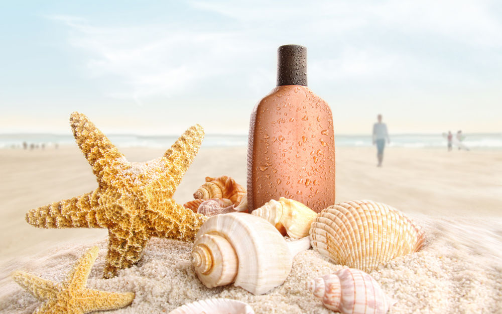Обои для рабочего стола Бутылка, ракушки и морская звезда на пляже, в далеке ходят люди