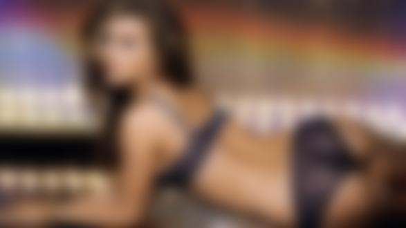 Обои на рабочий стол Carmen Electra / Кармен Электра в шикарном прозрачном белье лежит к нам спиной. Она повернулась, чтобы заглянуть в объектив фотокамеры