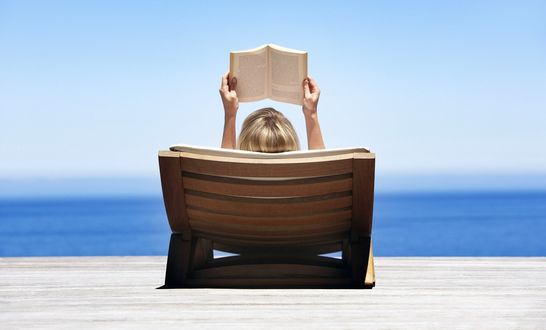Обои на рабочий стол Девушка читает книгу в шезлонге