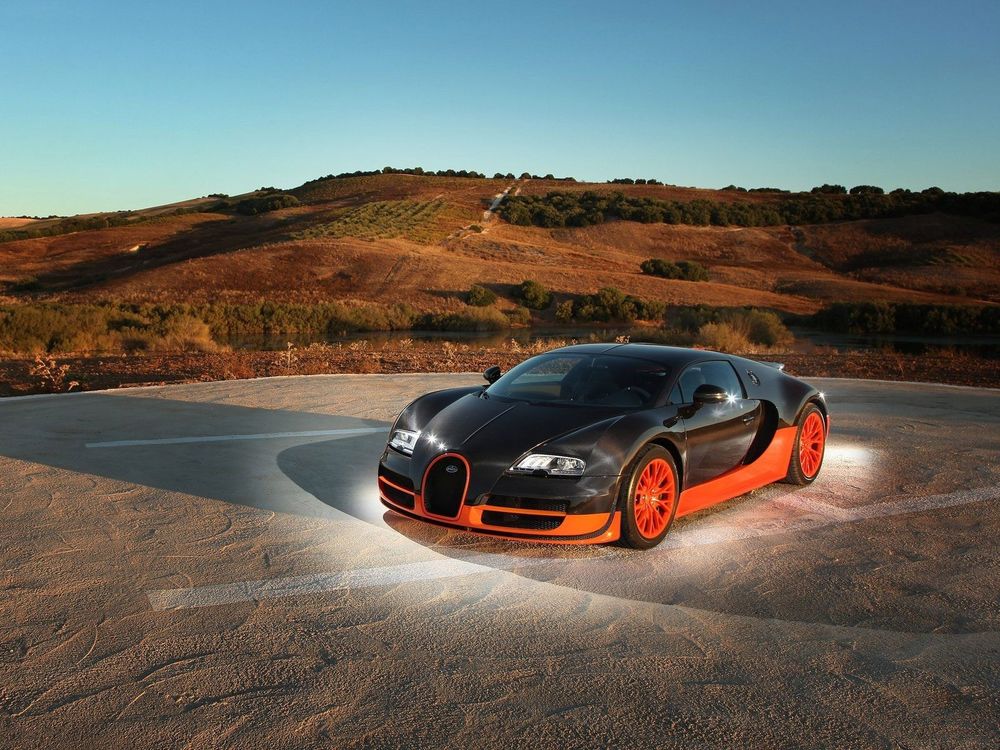 Обои для рабочего стола Bugatti / Бугатти Veyron Super Sport стоит на песочной стоянке