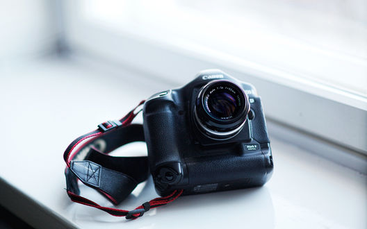 Обои на рабочий стол Фотоаппарат  Canon лежит на подоконнике
