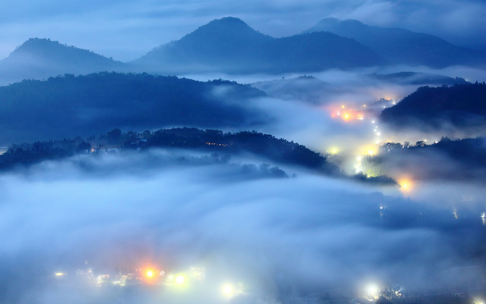 Обои для рабочего стола Туман лег на холмы и на город, светящийся вечерними огнями