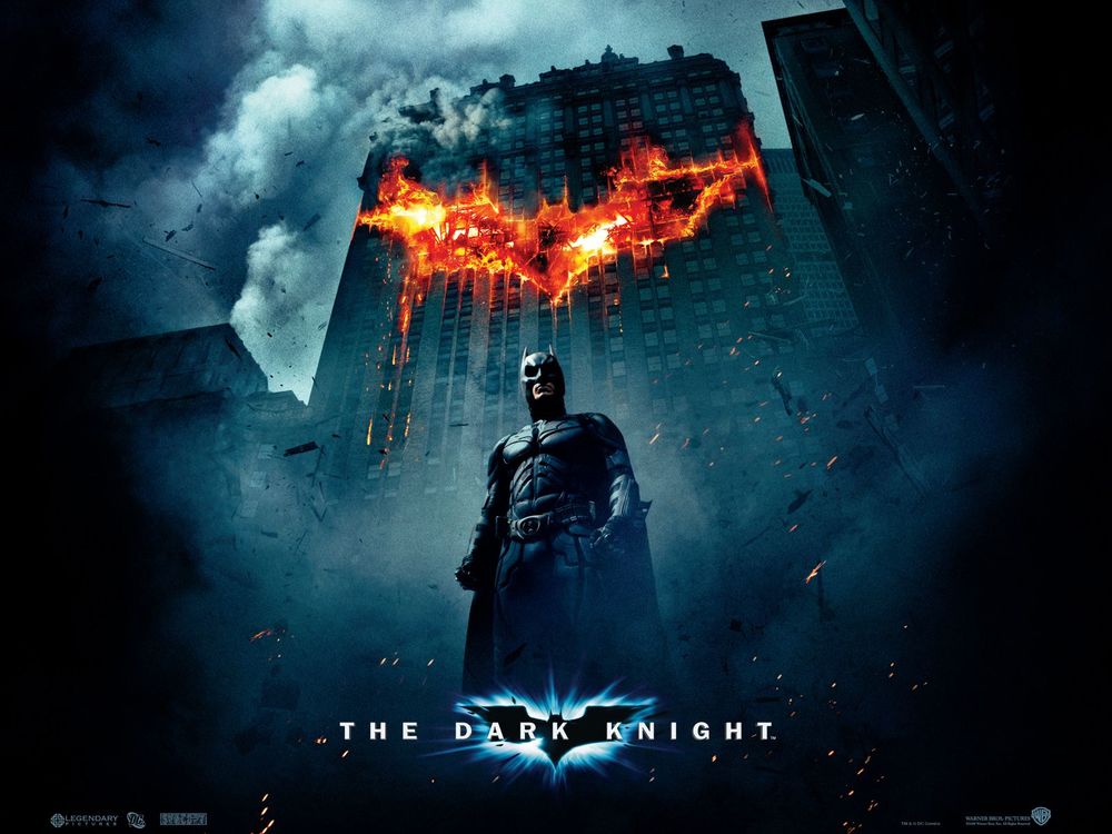 Обои для рабочего стола Бетмен  из фильма Темный Рыцарь / The Dark knight стоит на фоне горящего здания