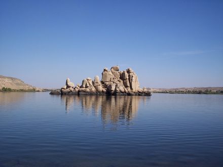 Обои на рабочий стол Остров из глиняных камней посреди морской глади