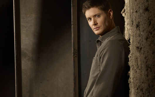 Обои на рабочий стол Известный актер Дженсен Эклс / Jensen Ackles стоит, облокотившись на стену