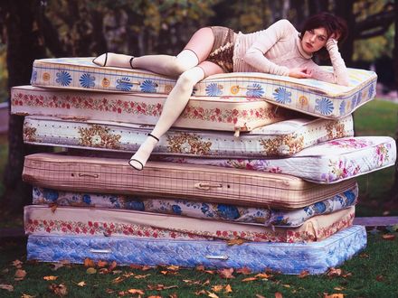 Обои на рабочий стол Milla Jovovich / Милла Йовович лежит на восьми разноцветных матрасах