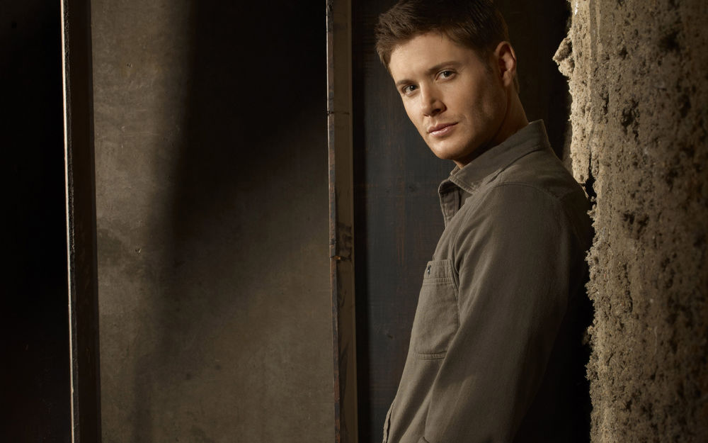 Обои для рабочего стола Известный актер Дженсен Эклс / Jensen Ackles стоит, облокотившись на стену