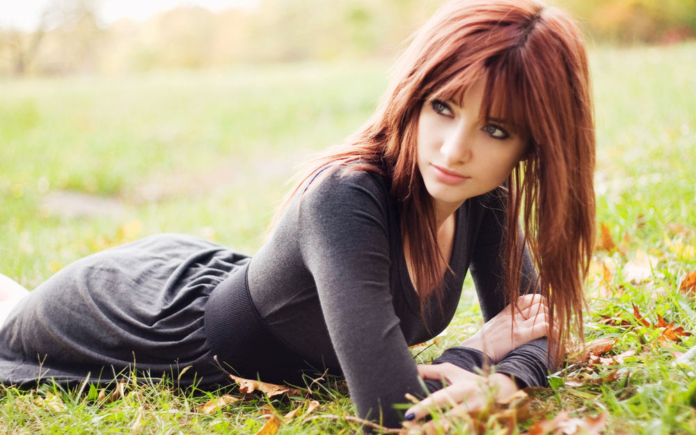 Обои для рабочего стола Susan Coffey / Сьюзан Кофи  лежит  на траве