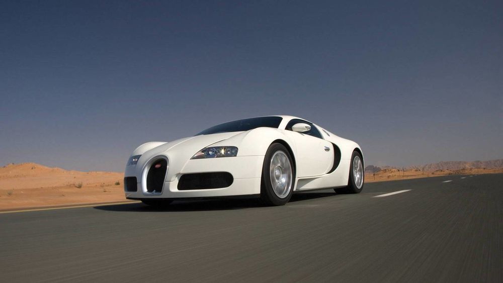 Обои для рабочего стола Bugatti Veyron / Белый Бугатти Вейрон едет в пустыне на фоне неба