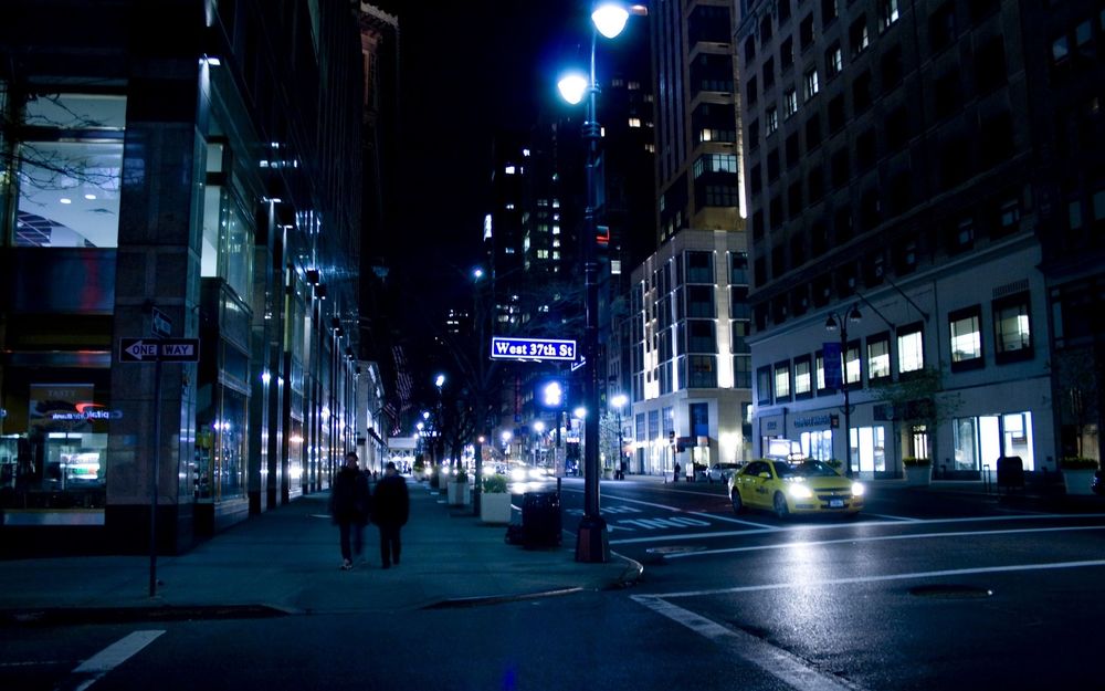 Обои для рабочего стола Нью-йорк / New york city ночью, по улицам ходят редкие прохожие и проезжают такси (West 37th ST)