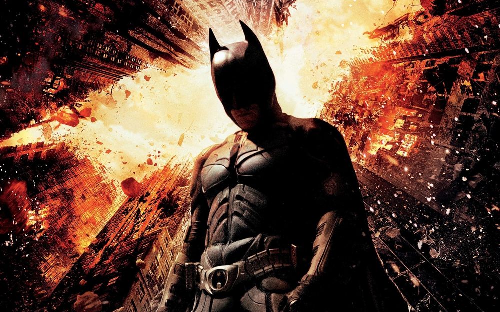 Обои для рабочего стола Постер к фильму Бэтмен: Возрождение легенды / Batman: Rise с изображением главного героя Бэтмена / Batman на фоне горящих зданий