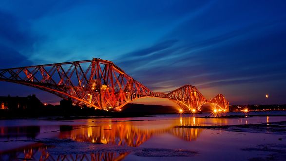 Обои на рабочий стол Железнодорожный мост Forth Bridge / Форт Бридж  освещенный ярким электрическим светом, в ночных условиях  и пролегающий через залив Firth of Forth / Ферт - оф – Форт,  Scotland / Шотландия, England / Англия