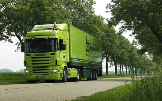 Обои на рабочий стол Тягач Scania / Скания салатового цвета на трассе, по краям которой растут деревья