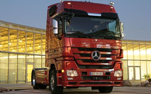 Обои на рабочий стол Красный тягач Мерседес / Mercedes без прицепа, позади него стеклянное здание