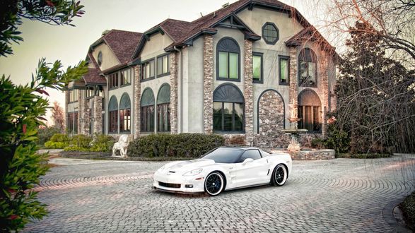 Обои на рабочий стол Автомобиль белого цвета марки Chevrolet Corvette ZR1 припаркован возле двухэтажного красивого дома с коричневой черепичной крышей