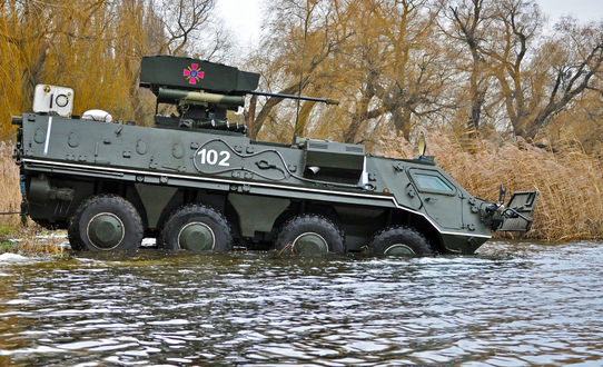 Обои на рабочий стол Боевой бронетранспортер БТР-4 Украинской Армии пытается преодолеть водную преграду на фоне деревьев с желтыми осенними листьями