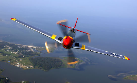 Обои на рабочий стол Самолет North American P-51 Mustang / Норт Америкэн Р-51 Мустанг-американский истребитель периода Второй Мировой войны пролетает над водным пространством с островами