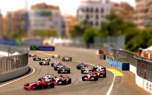 Обои на рабочий стол Чемпионат мира Формулы-1 / FLA Formula One World Championship / на одной из многочисленных трасс на фоне многоэтажных домов и деревьев, с эффектом тилт шифт /tilt shift