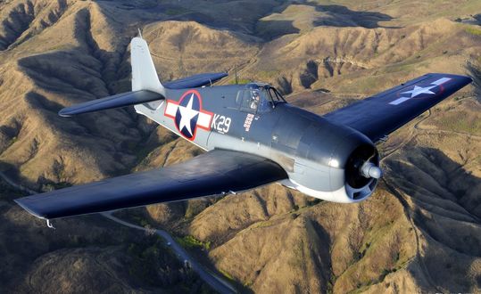 Обои на рабочий стол Самолет F6F-3 Хелкэт, США /F6F-3 Hellcat, USA-палубный истребитель Второй мировой войны пролетает над горным массивом